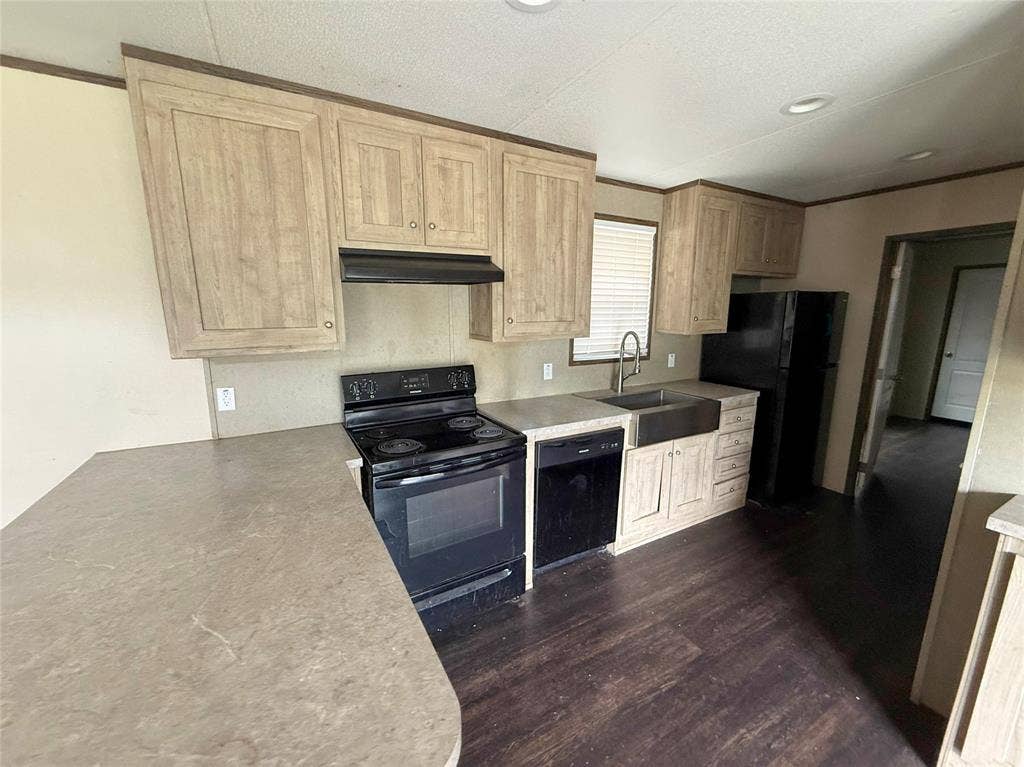716 Quail Run Court, Seven Points, TX 75143 Kitchen featuring wood-finish cabinetry, dark wood-finish flooring, a stainless steel farmhouse sink with a gooseneck faucet, black appliances, and neutral countertops