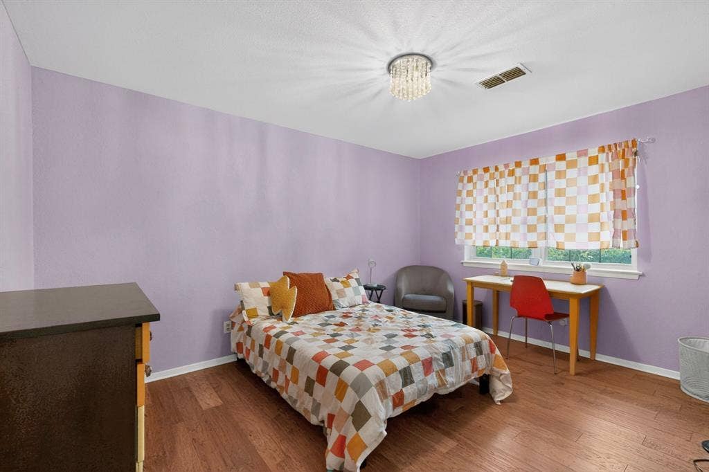 1151 Lynn Way, Waxahachie, TX 75165 Interior room featuring wood-finish flooring, a contemporary ceiling light fixture, a window with exterior views, and light purple wall paint
