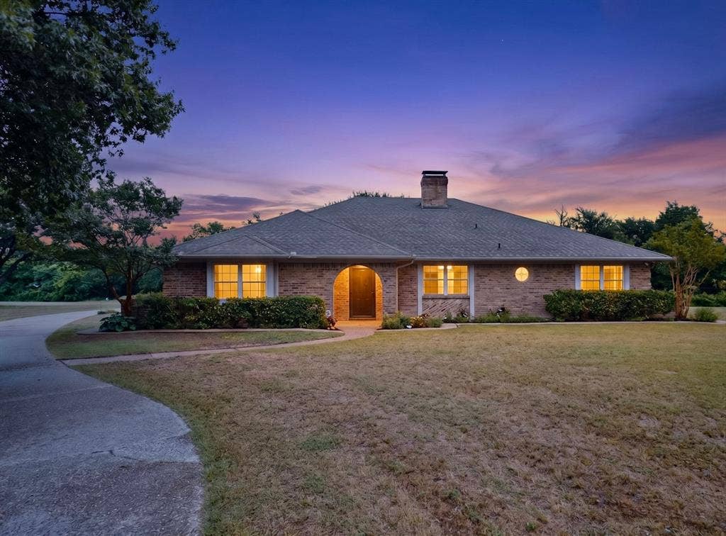 1151 Lynn Way, Waxahachie, TX 75165 Brick exterior residence with a prominent chimney and a dark shingle roof