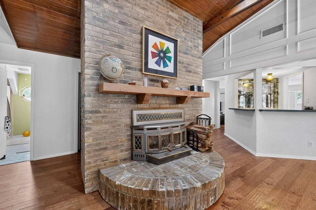 1151 Lynn Way, Waxahachie, TX 75165 Brick fireplace with a wood mantel, wood-finish flooring, and a vaulted wood-paneled ceiling