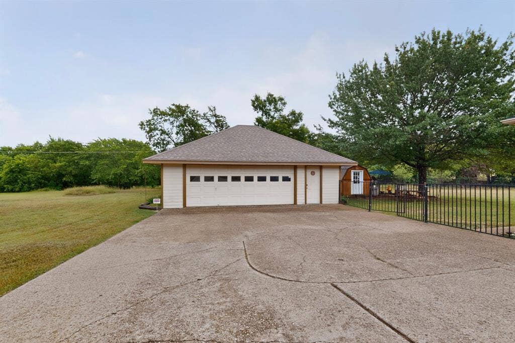 1151 Lynn Way, Waxahachie, TX 75165 Detached two-car garage with a pitched roof and a concrete driveway