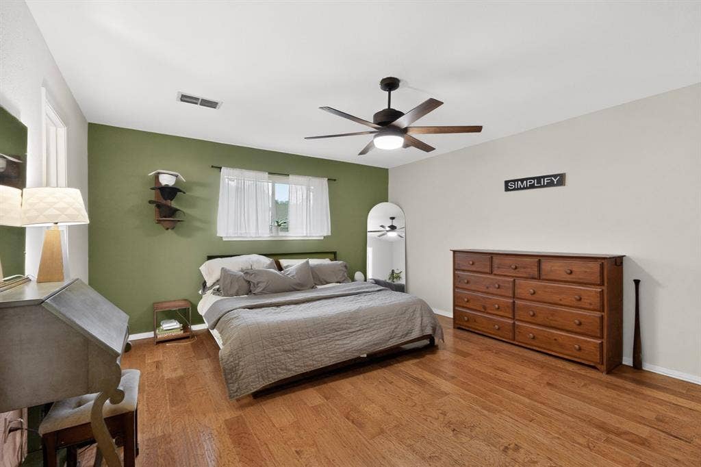 1151 Lynn Way, Waxahachie, TX 75165 Bedroom featuring wood-finish flooring, a ceiling fan with integrated lighting, and a window with sheers