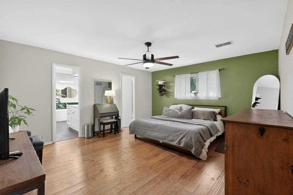 1151 Lynn Way, Waxahachie, TX 75165 Spacious bedroom featuring wood-finish flooring, a ceiling fan with integrated lighting, and a window with natural light