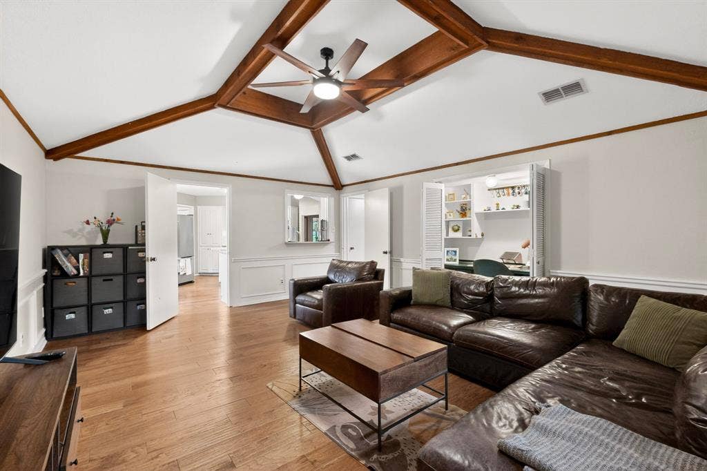 1151 Lynn Way, Waxahachie, TX 75165 Living area featuring vaulted ceilings with exposed wood beams, wood-finish flooring, wainscoting, and a built-in desk with shelving