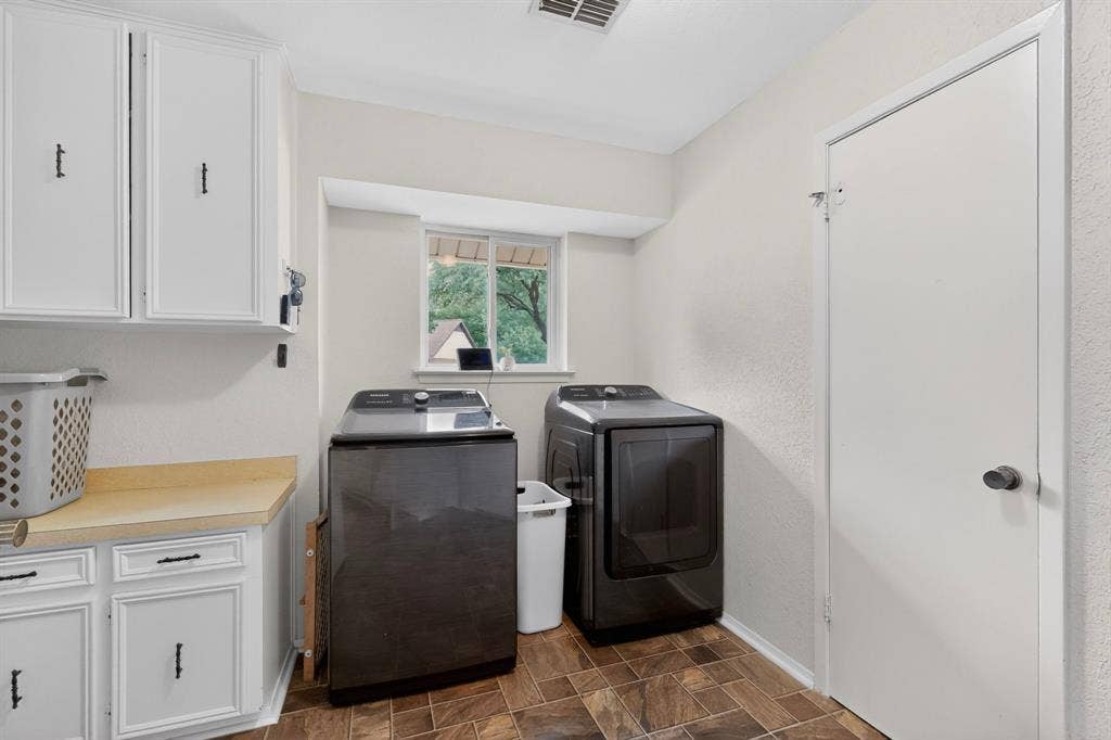1151 Lynn Way, Waxahachie, TX 75165 Functional utility room featuring white cabinetry with dark hardware, a light-toned countertop, a window, and tile flooring