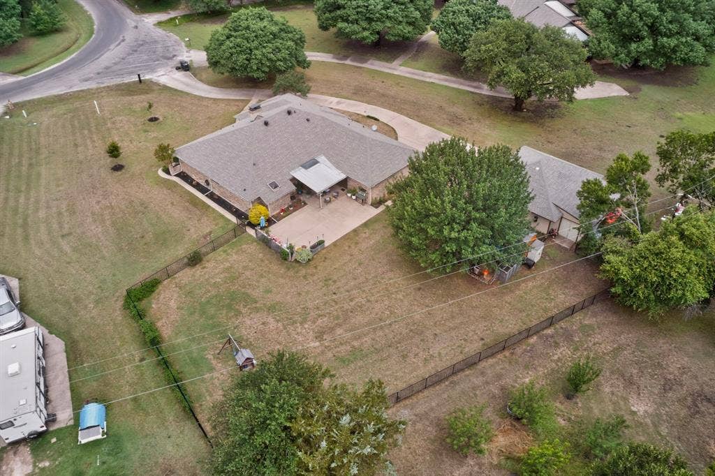 1151 Lynn Way, Waxahachie, TX 75165 Expansive property featuring a single-story residence with a covered patio, a detached auxiliary structure, and a fenced perimeter