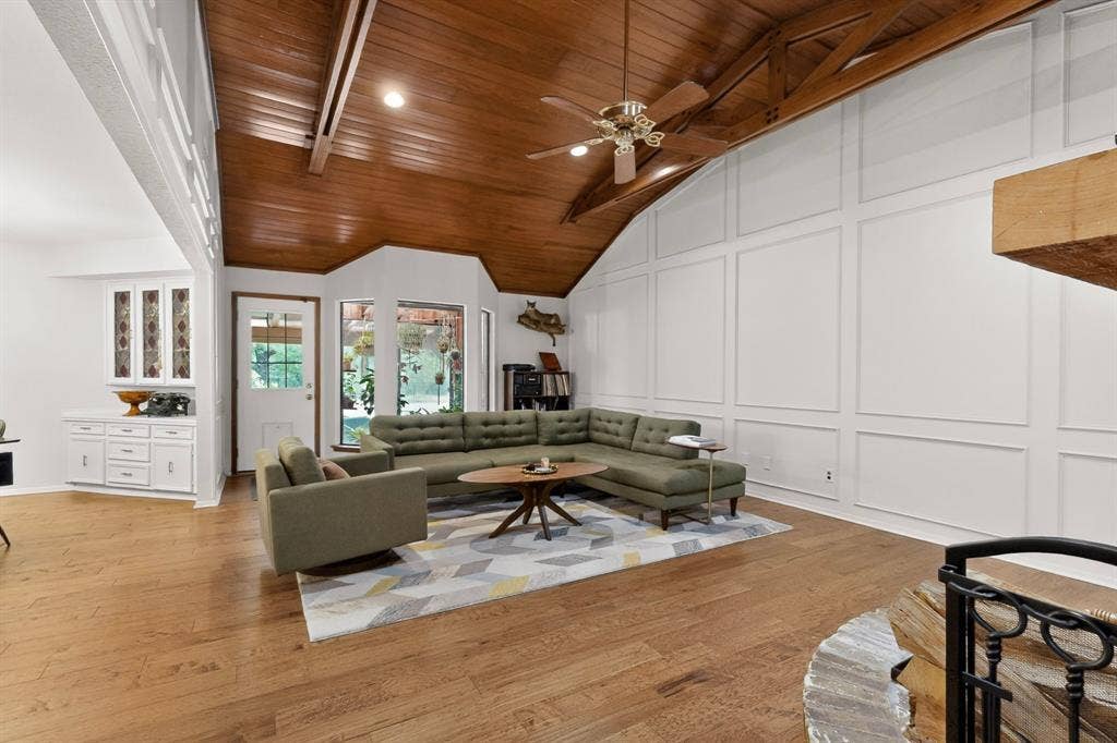 1151 Lynn Way, Waxahachie, TX 75165 Vaulted wood-finish ceiling with exposed beams, wood-finish flooring, white paneled accent wall, built-in white cabinetry, and multi-pane windows