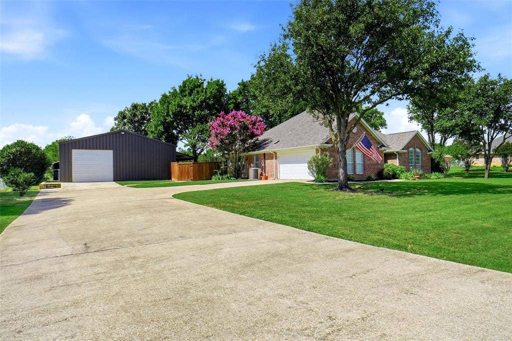 Expansive concrete driveway leading to the primary residence and the barndominium.