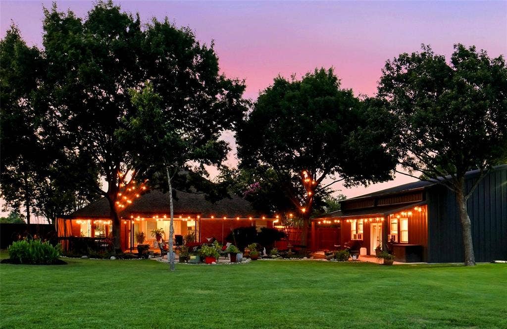 Backyard with landscaping, string lighting, and mature trees