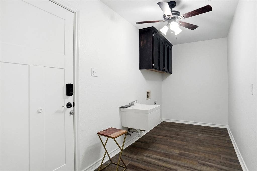 Utility room featuring LVP wood-finish flooring, washer and dryer connections, and a mop sink