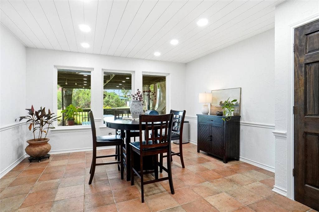 Dining area with white shiplap ceiling, recessed lighting, and views of the covered patio
