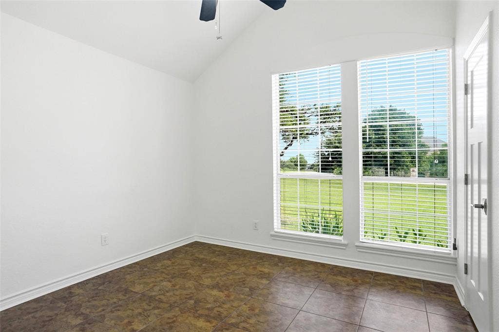 Bedroom featuring large windows with horizontal blinds, a ceiling fan with light fixture, tiled flooring, and a closet