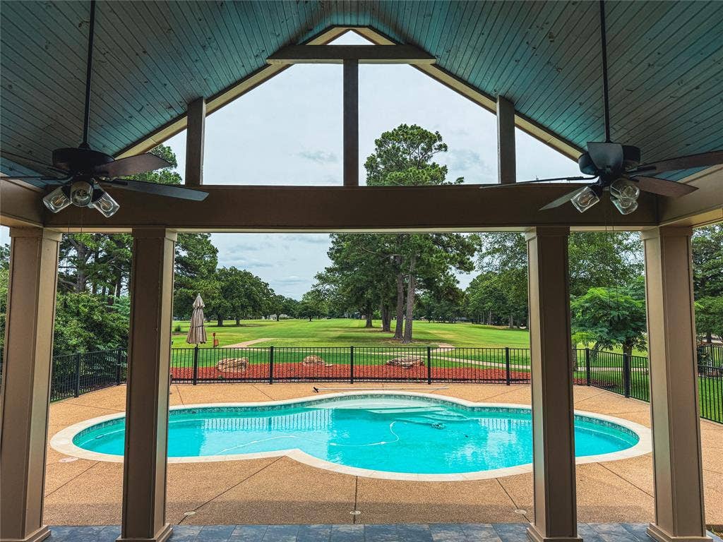 5 Woodlawn Way, Star Harbor, TX 75148 Covered patio featuring a vaulted wood-plank ceiling with a blue finish, two ceiling fans with integrated lighting, and substantial support columns