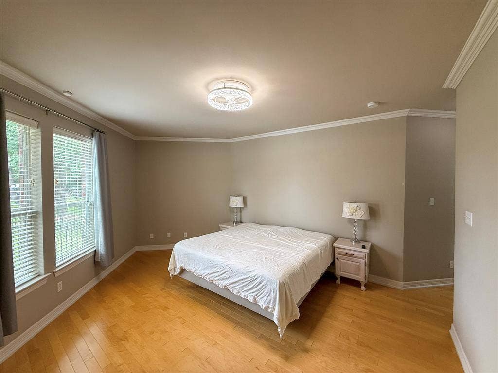 5 Woodlawn Way, Star Harbor, TX 75148 Spacious room featuring light wood-finish flooring, multiple windows, and a decorative ceiling light fixture