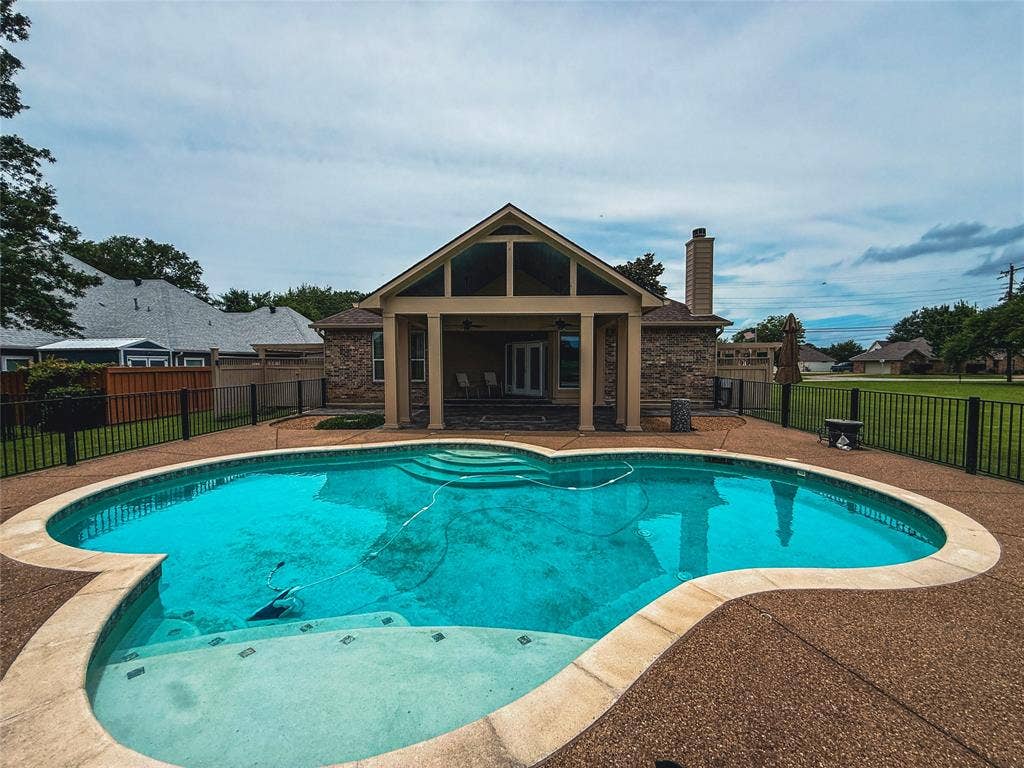 5 Woodlawn Way, Star Harbor, TX 75148 Kidney-shaped swimming pool with integrated steps, surrounded by an exposed aggregate patio