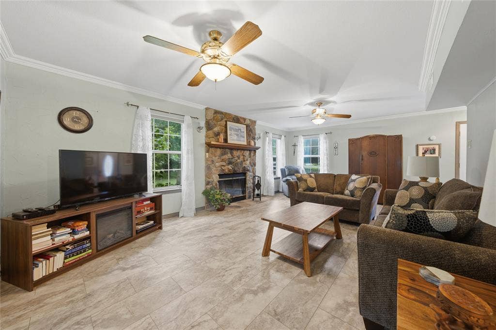 2746 Hopson Drive, Athens, TX 75752 Spacious living area featuring tile flooring, a stone-front fireplace with a wood mantel, and multiple windows