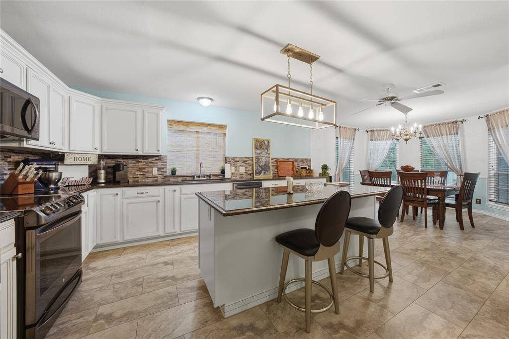 2746 Hopson Drive, Athens, TX 75752 Spacious kitchen featuring white cabinetry, dark stone countertops, and a stone tile backsplash