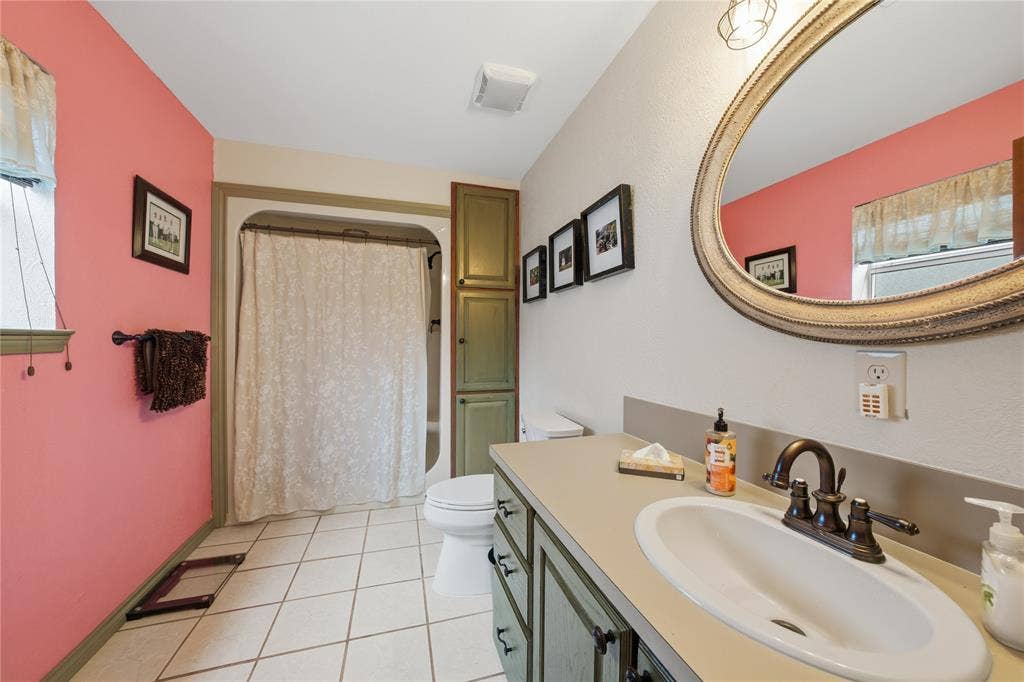 2746 Hopson Drive, Athens, TX 75752 Bathroom featuring a vanity with an integrated sink, bronze-finish faucet, and a large ornate mirror