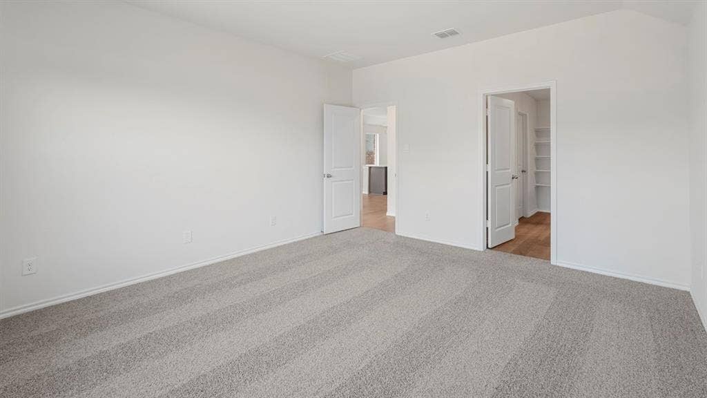 1659 Blaire Drive, Tyler, TX 75702 Spacious room featuring light gray carpeting, crisp white walls, and bright white trim
