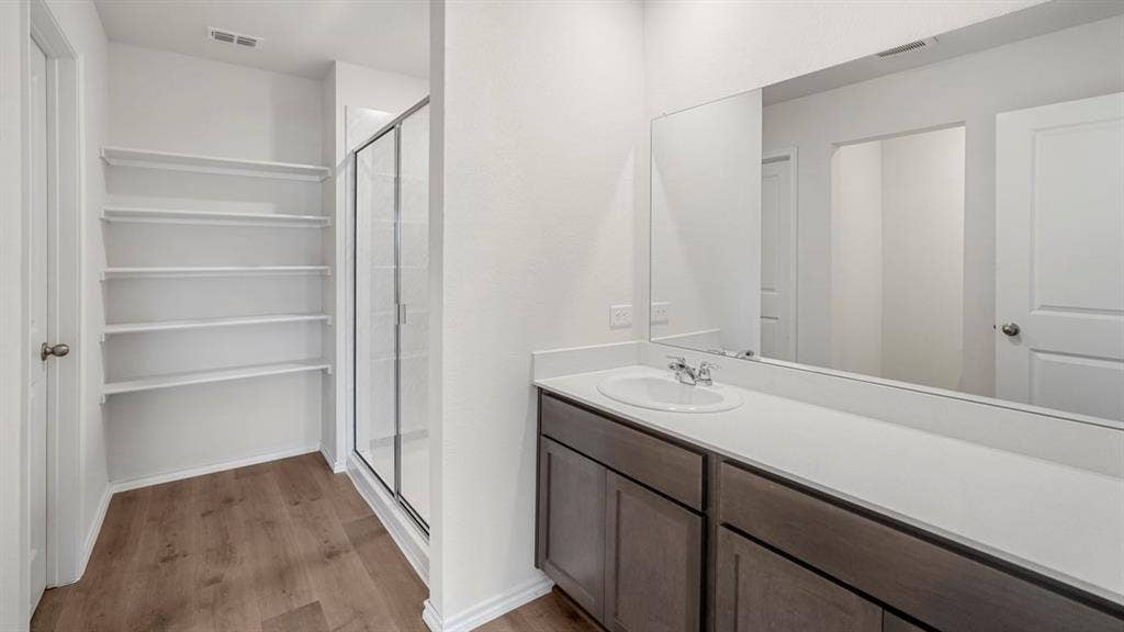 1659 Blaire Drive, Tyler, TX 75702 Bathroom featuring a spacious vanity with an integrated sink and an expansive mirror