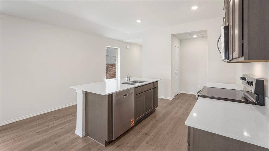 1659 Blaire Drive, Tyler, TX 75702 Modern kitchen featuring an island with a double basin sink, stainless steel dishwasher, and white countertops