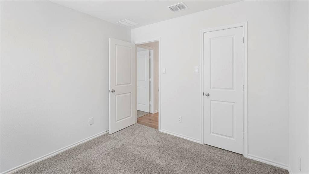 1659 Blaire Drive, Tyler, TX 75702 Neutral-toned walls and gray patterned carpet create a versatile backdrop