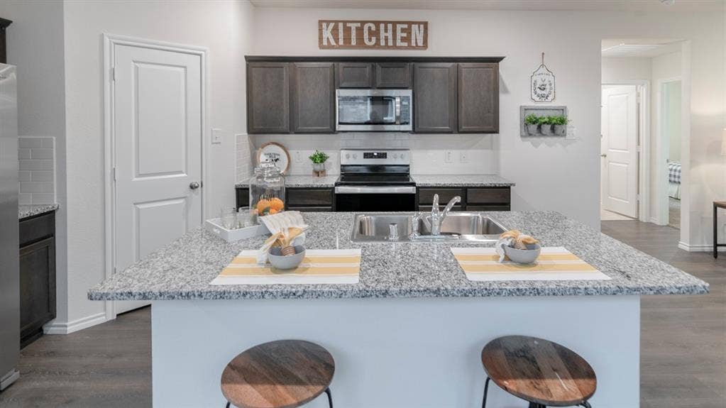 1627 Blaire Drive, Tyler, TX 75702 Kitchen featuring an expansive island with a double basin sink and granite-style countertop