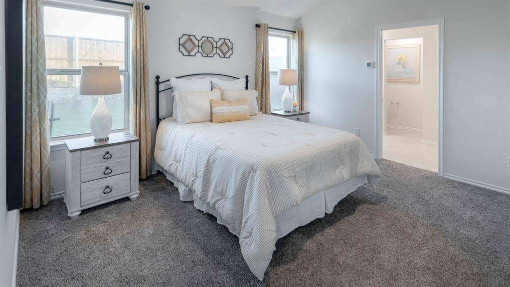 1627 Blaire Drive, Tyler, TX 75702 Carpeted bedroom featuring two windows, a white door frame, and light gray walls