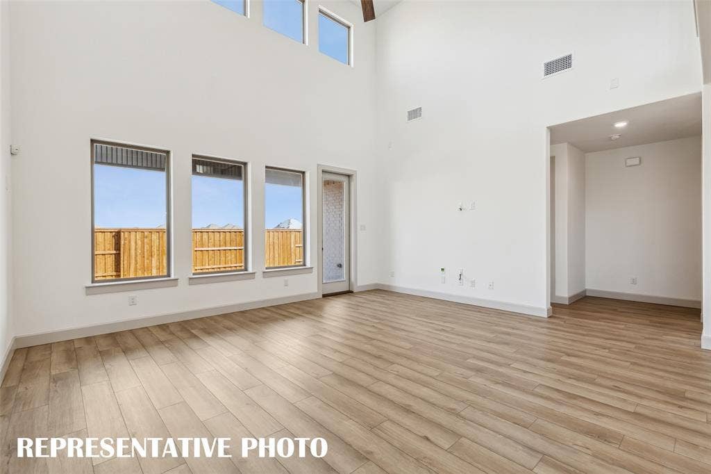 1290 Chickadee Street, Prosper, TX 75078 A wall of windows flood this family room with natural light. REPRESENTATIVE PHOTO