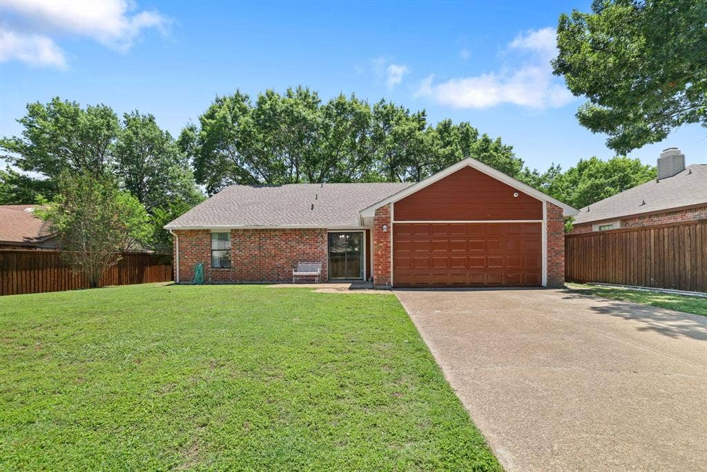 1037 Whitewater Trail, DeSoto, TX 75115 Brick exterior featuring a two-car garage with a wood-finish door, a concrete driveway, and a front lawn