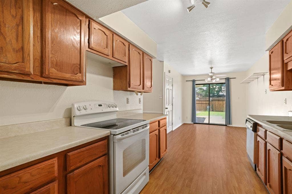 1037 Whitewater Trail, DeSoto, TX 75115 Kitchen featuring wood cabinetry, light-toned countertops, and a white electric range