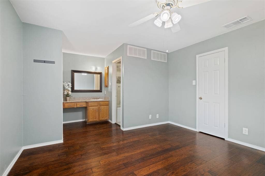 4130 Proton Drive, #47B, Addison, TX 75001 Secondary bedroom showing the built-in vanity with granite countertop, closet, and en-suite bath access — a functional layout that offers privacy and convenience for guests or a second occupant.