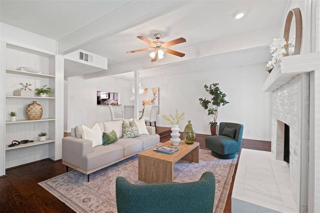 4130 Proton Drive, #47B, Addison, TX 75001 Living room with built-in shelving, open sightlines to the dining area and kitchen, and a tile-surround fireplace — an ideal layout for both entertaining and everyday living.