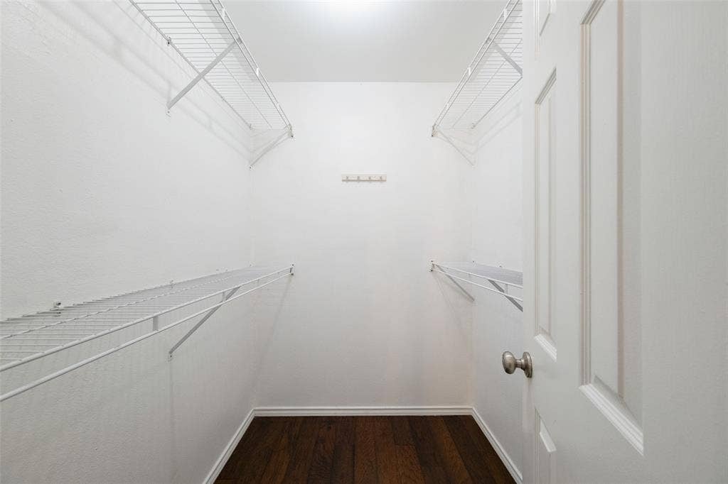 4130 Proton Drive, #47B, Addison, TX 75001 Generously sized walk-in closet off the primary suite with dual hanging rods, upper shelving on both sides, and hardwood floors — plenty of room to customize to your storage needs.