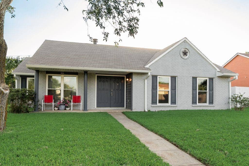 316 Matterhorn Street, Cedar Hill, TX 75104 Gray brick facade with dark gray shutters and an arched entryway