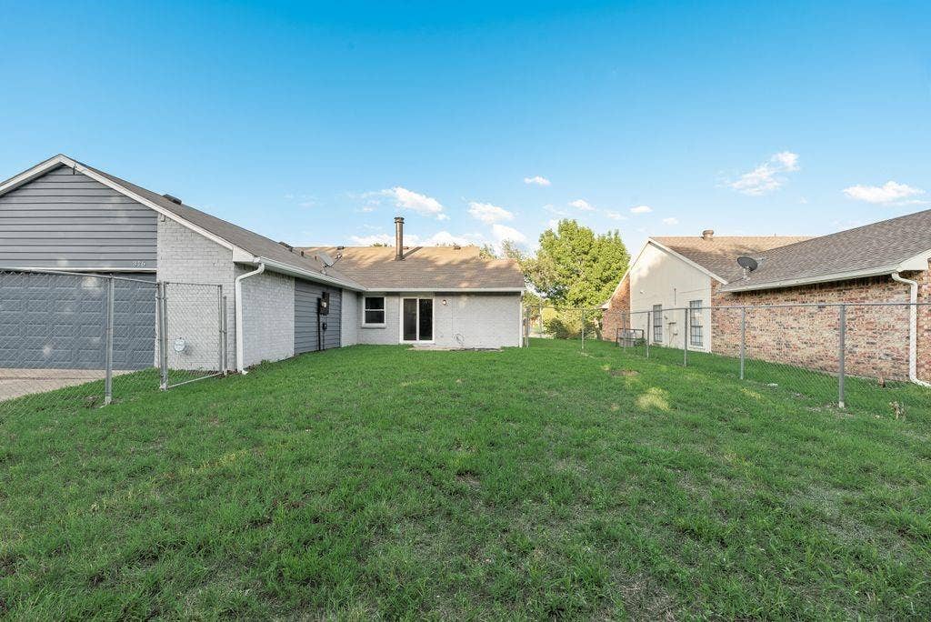 316 Matterhorn Street, Cedar Hill, TX 75104 Expansive backyard featuring a chain-link fence, mature lawn, and a back patio