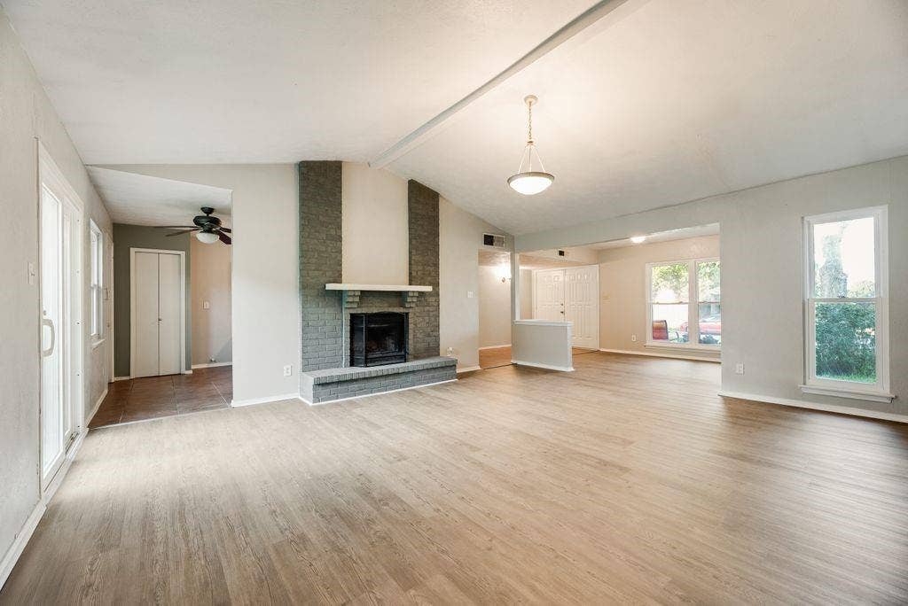 316 Matterhorn Street, Cedar Hill, TX 75104 Spacious living area featuring wood-finish flooring, a vaulted ceiling, and a brick fireplace
