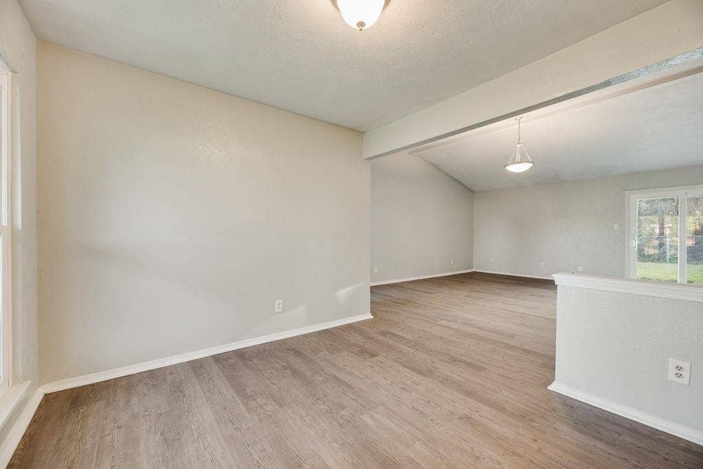 316 Matterhorn Street, Cedar Hill, TX 75104 Open-concept living area featuring wood-finish flooring, vaulted ceilings, and a sliding glass door to the exterior