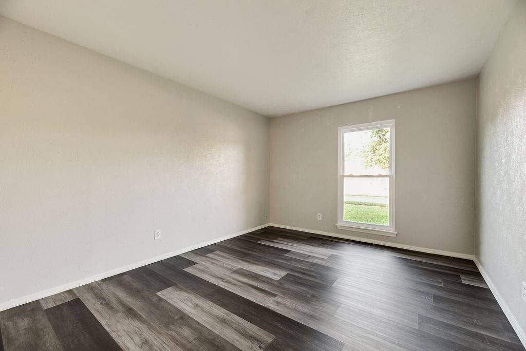 316 Matterhorn Street, Cedar Hill, TX 75104 Room featuring dark wood-finish flooring, light neutral-toned walls, a white trim baseboard, a single window with white framing, and a smooth white ceiling