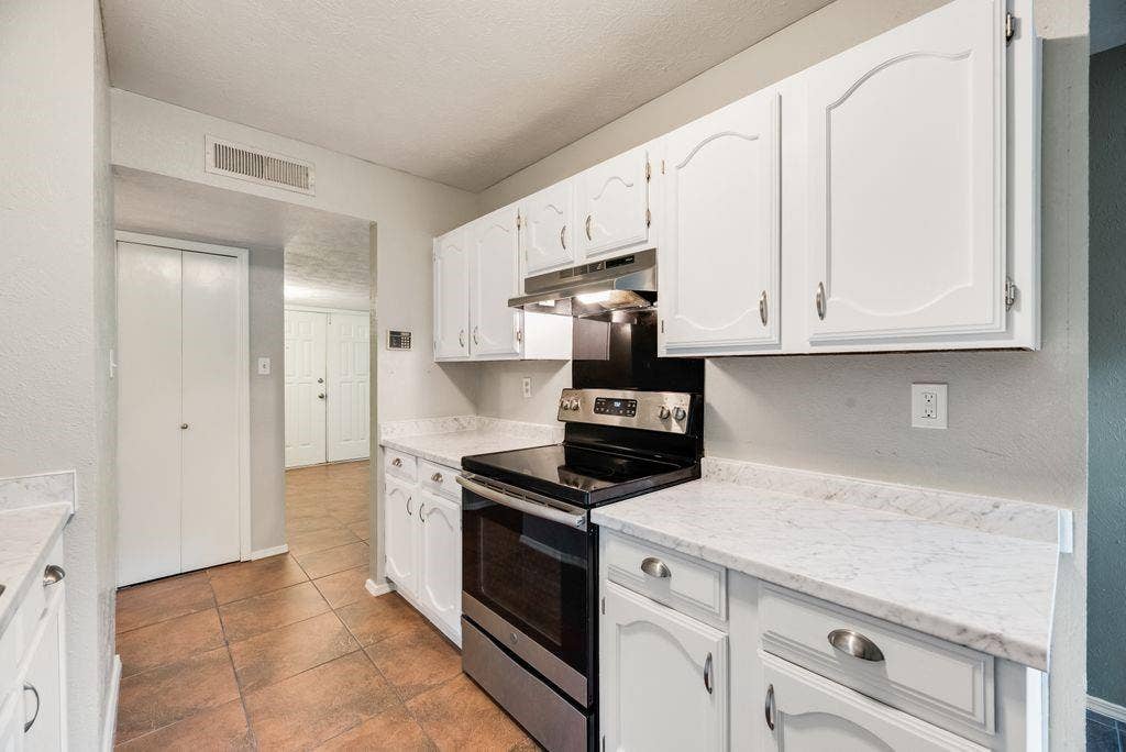 316 Matterhorn Street, Cedar Hill, TX 75104 Kitchen featuring white cabinetry, stainless steel range, white countertops, and terracotta-toned tile flooring