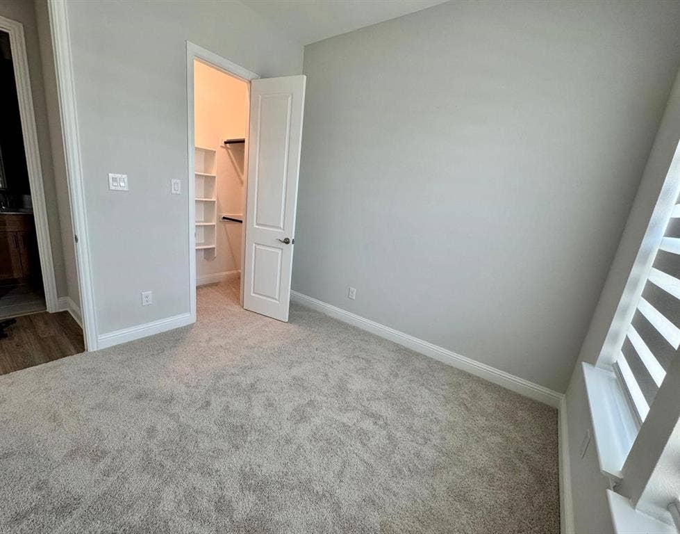 2930 Eleanor Drive, Prosper, TX 75078 Unfurnished bedroom with a walk in closet and carpet floors