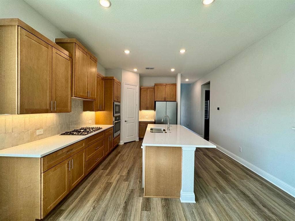 2930 Eleanor Drive, Prosper, TX 75078 Kitchen featuring dark wood-style floors, light countertops, decorative backsplash, stainless steel appliances, and recessed lighting