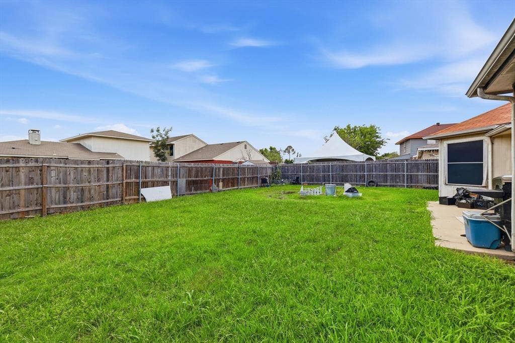 6406 Nicole Way, Arlington, TX 76002 Expansive grassy backyard featuring a full wood privacy fence and concrete patio