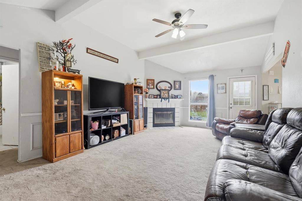 6406 Nicole Way, Arlington, TX 76002 Spacious living area featuring vaulted ceilings, a ceiling fan, fireplace, and light-colored carpeting