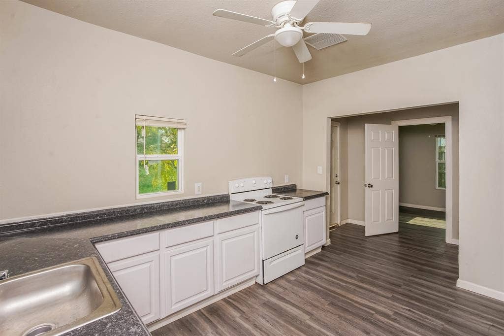 2402 Summer Avenue, Waco, TX 76708 Kitchen featuring white cabinetry, dark speckled countertops, and a stainless steel sink