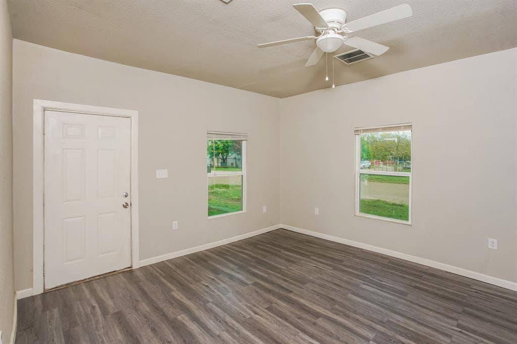 2402 Summer Avenue, Waco, TX 76708 Interior room featuring wood-finish flooring, two windows, and a ceiling fan
