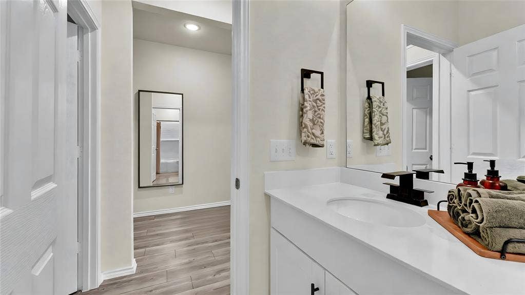 707 Indigo Road, Princeton, TX 75407 Bathroom vanity featuring an integrated sink, white countertop, and dark-finish faucet