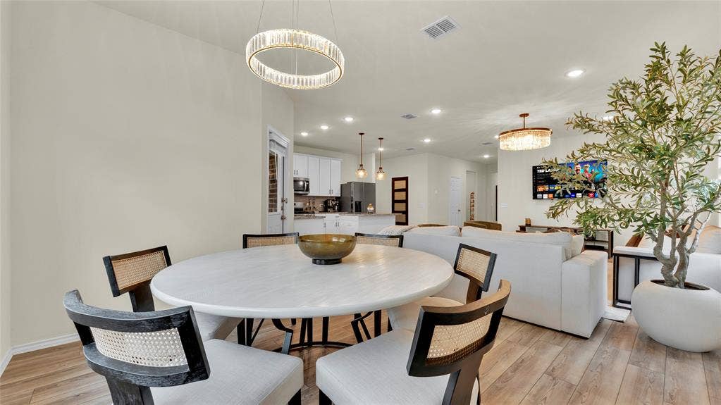 707 Indigo Road, Princeton, TX 75407 Open-concept living area featuring wood-finish flooring, recessed lighting, and a modern chandelier