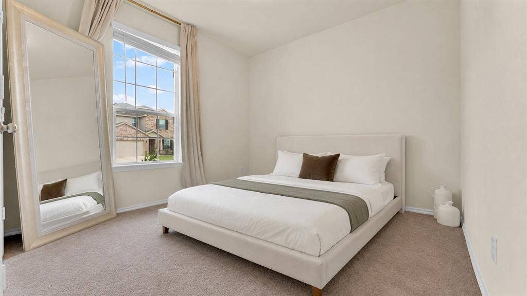 707 Indigo Road, Princeton, TX 75407 Carpeted room featuring a large window with grid panes, neutral wall paint, and white baseboards