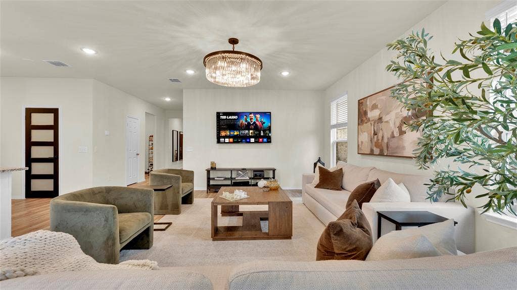 707 Indigo Road, Princeton, TX 75407 Expansive living area featuring recessed lighting, a contemporary chandelier, wood-finish flooring, and white walls